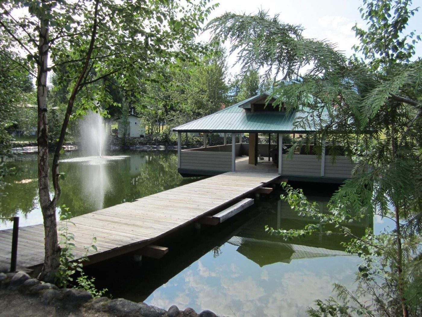 A wooden dock leading across a pond to an overwater building