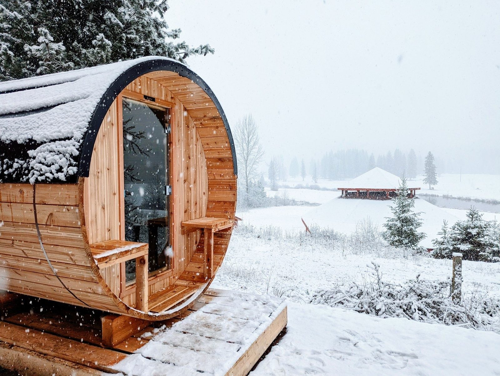 A barrel sauna dusted with fresh snow